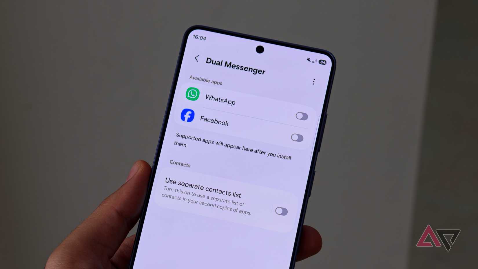 A hand holding a Samsung phone showing the Dual Messenger menu