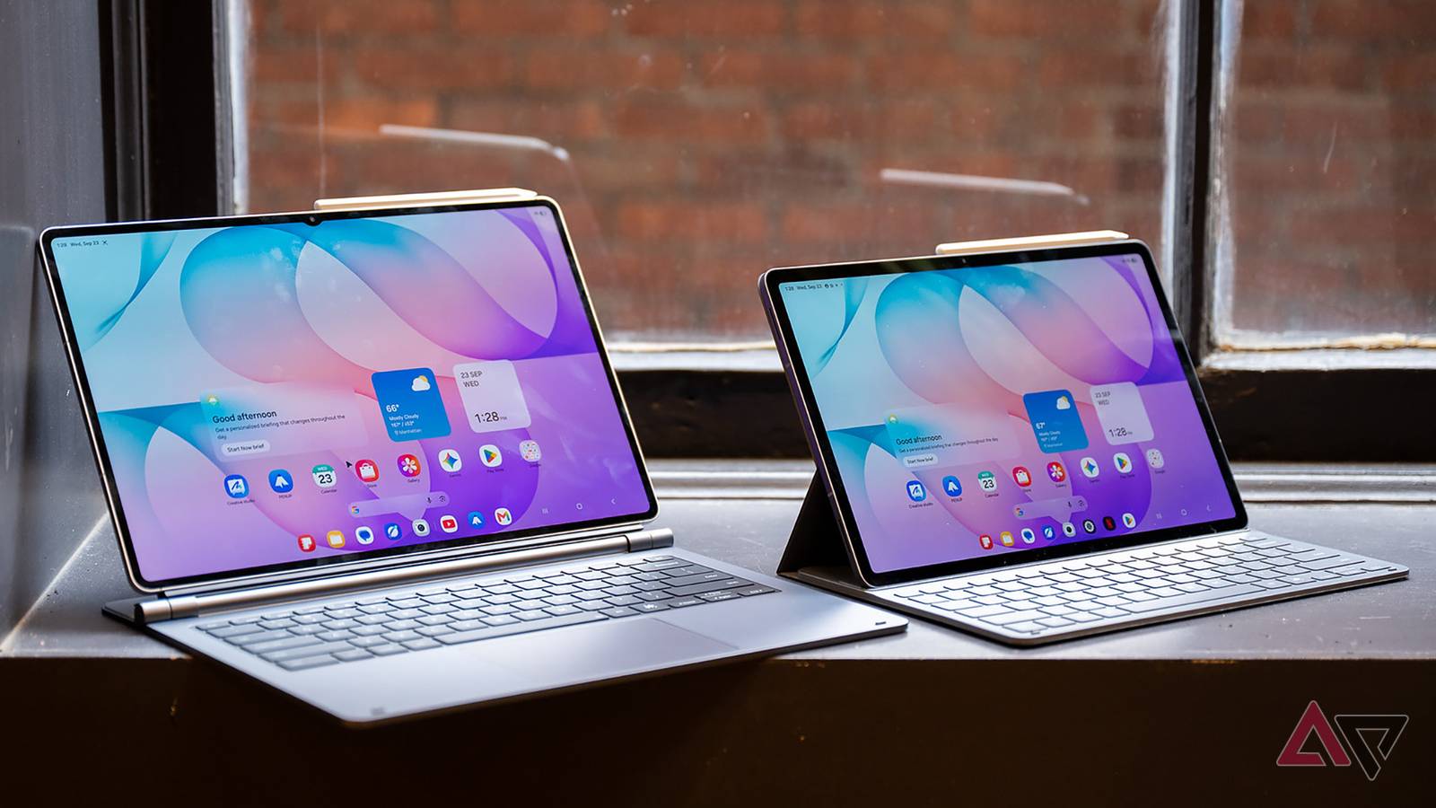 Samsung Galaxy Tab S12 Ultra with the Pro Keyboard beside a Samsung Galaxy Tab S12+ with the Book Cover Keyboard Slim on a window ledge.