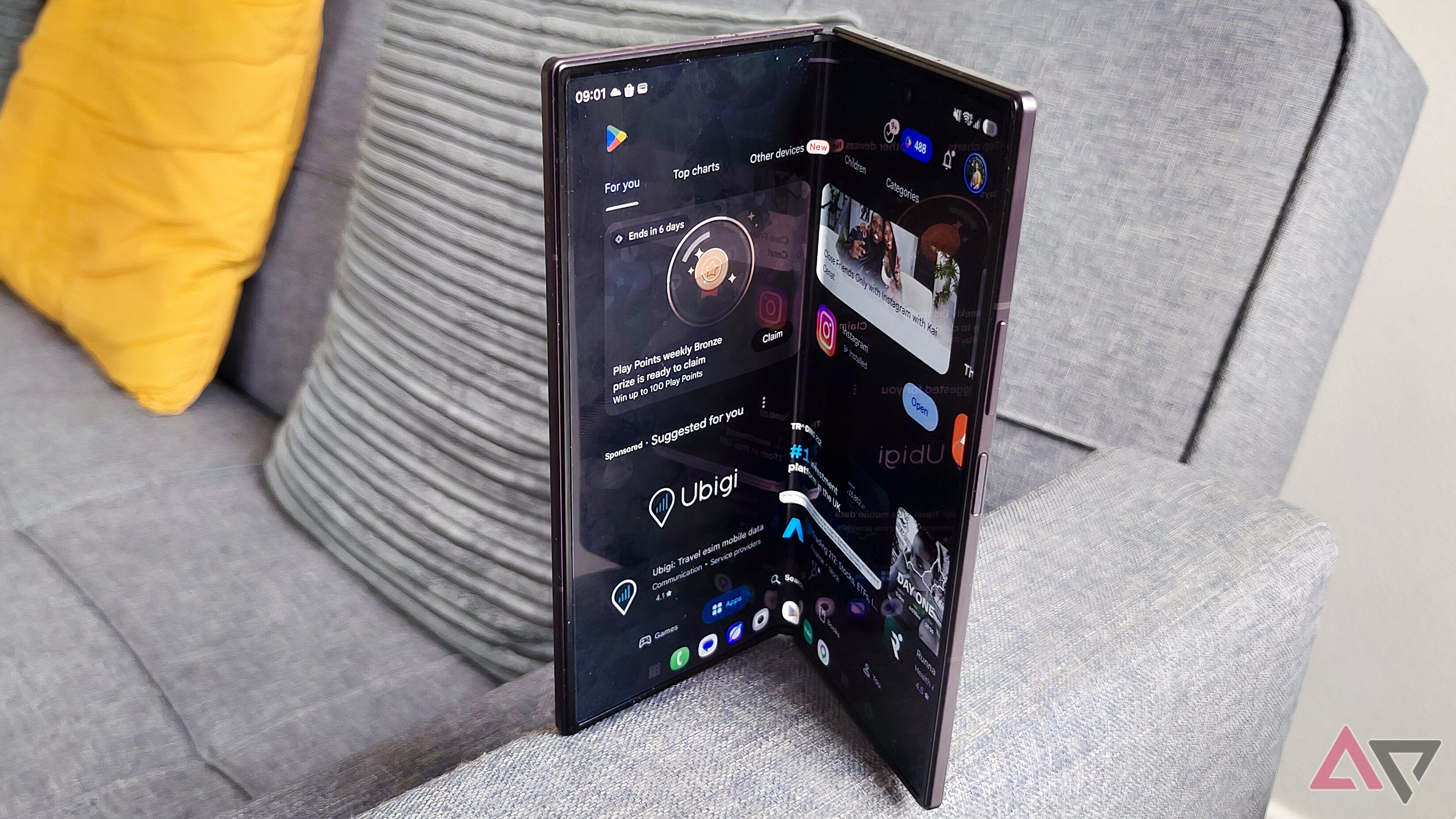 The Samsung Galaxy Z Fold 8, flexed on the arm of a sofa, showing the Play Store.