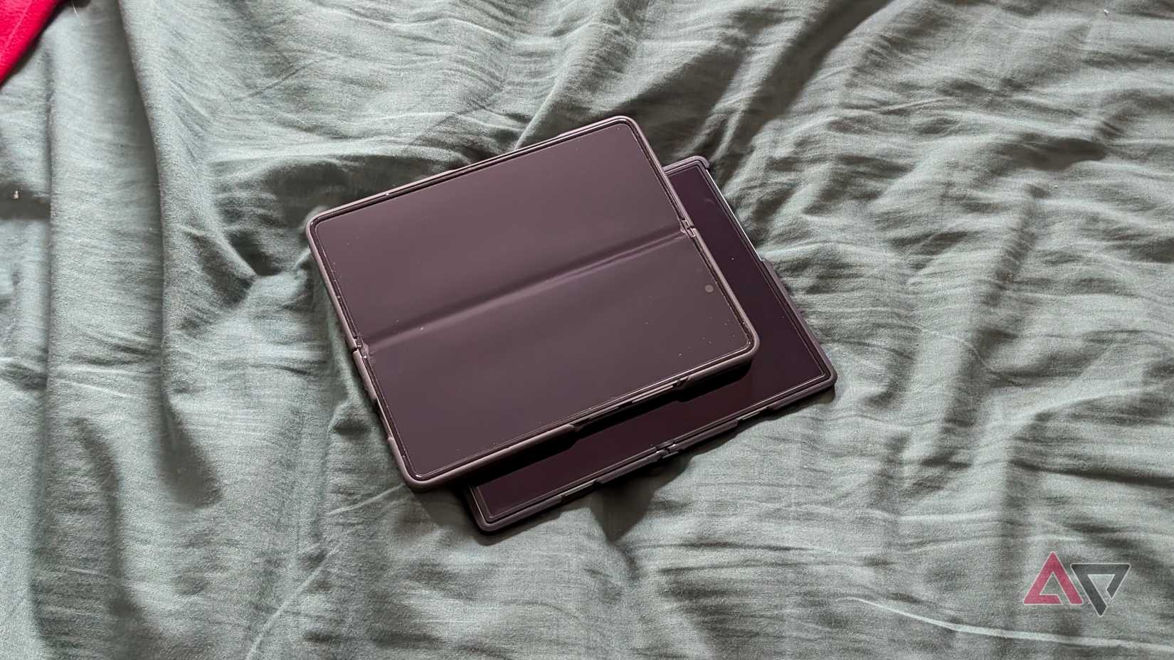The Z Fold 8 and 5, both open on a green bedsheet.