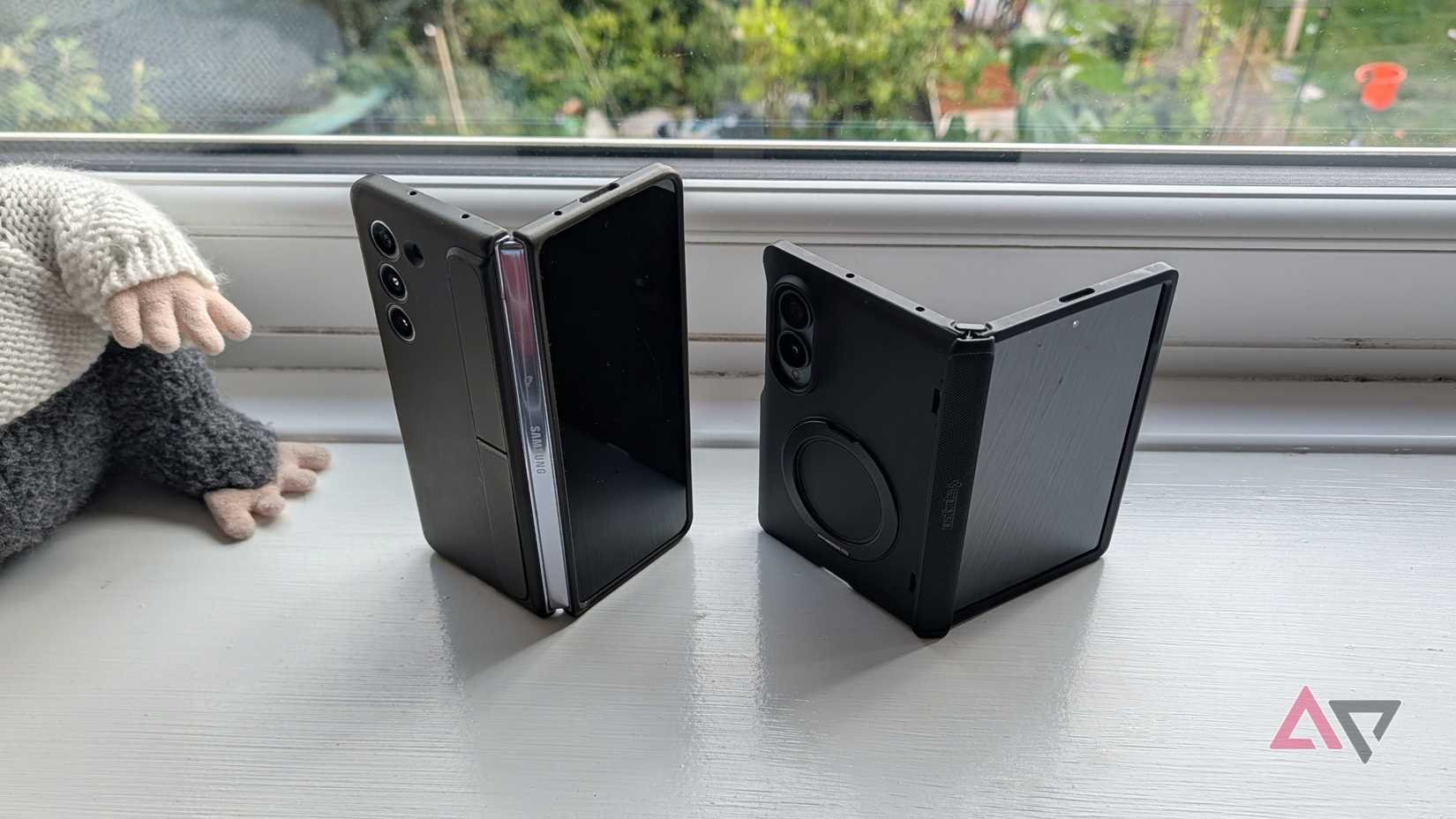 The Z Fold 8 and 5 on a windowsill, half-open.