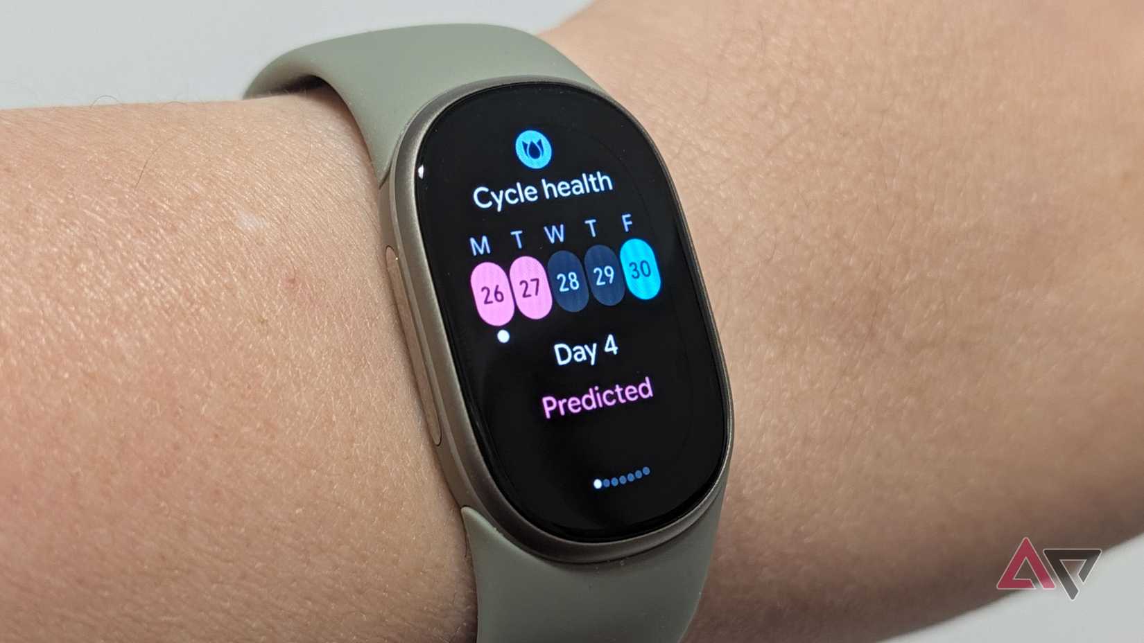 Google Fitbit Edge on a wrist showing Cycle Health period prediction screen