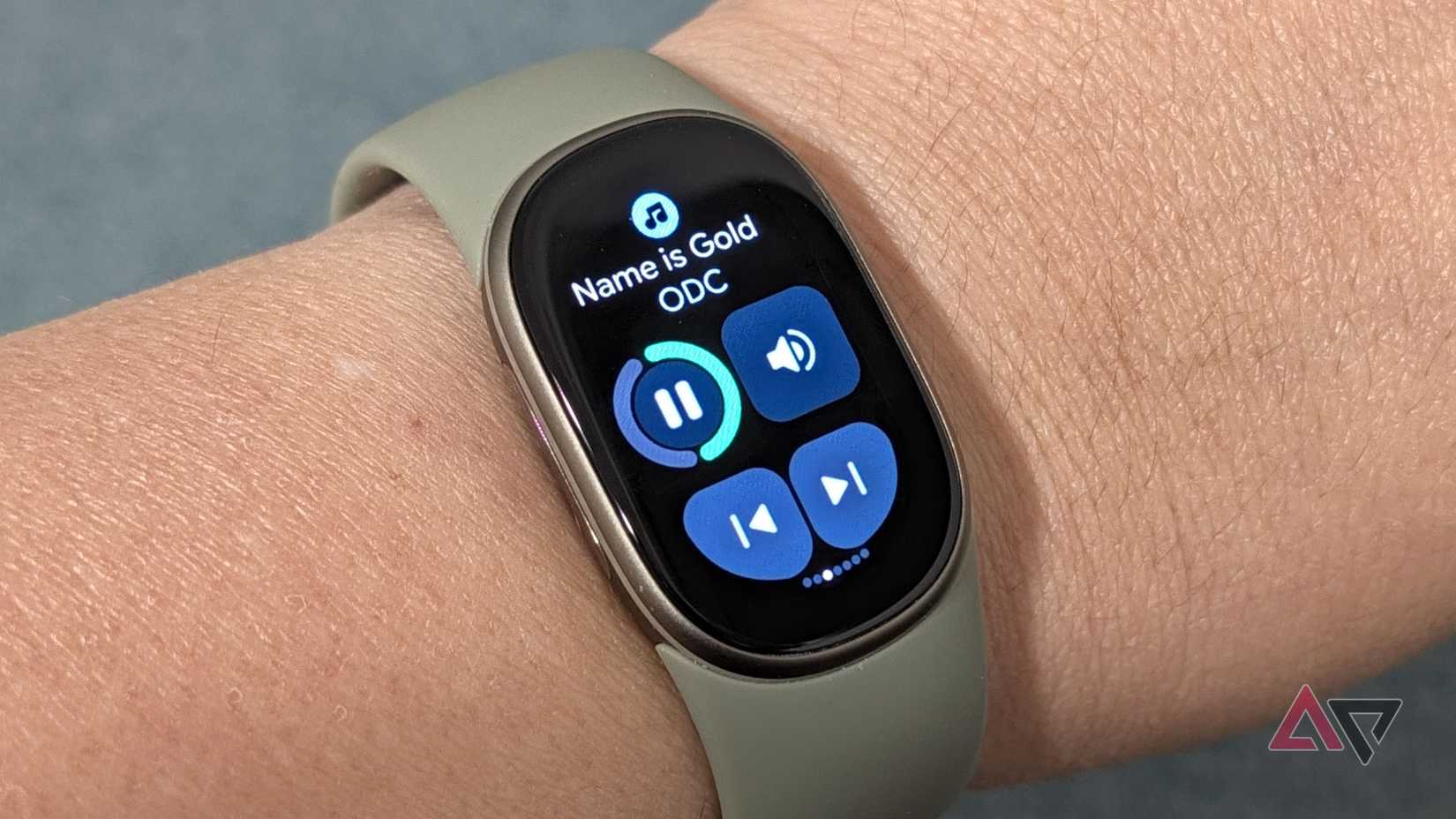 Google Fitbit Edge on a wrist showing Spotify music controls