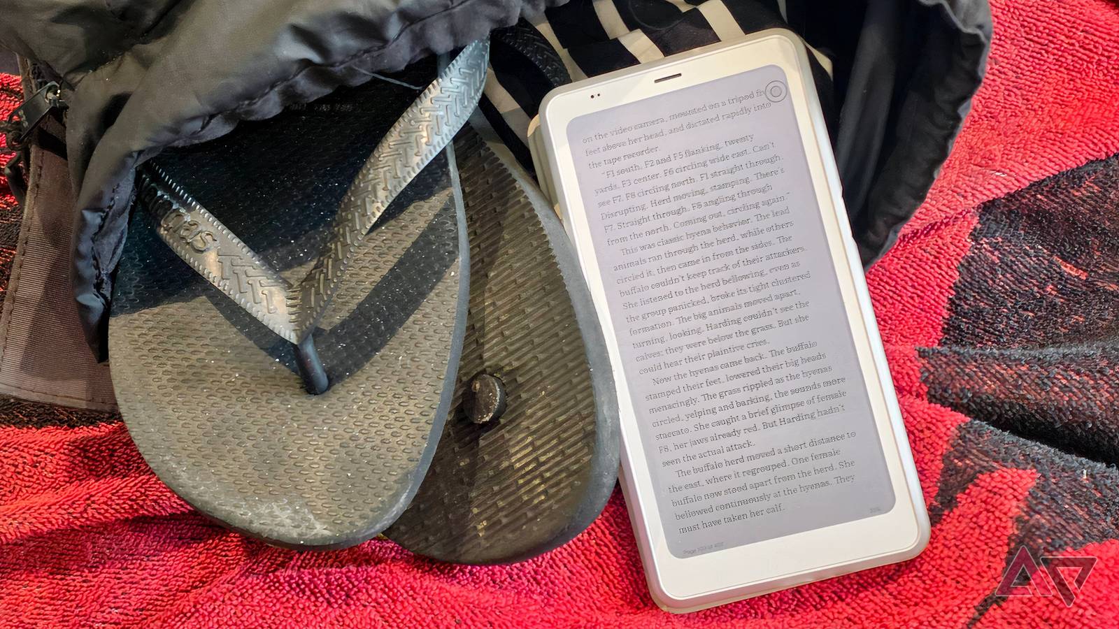 The Onyx Palma 2 Pro, with a book displayed, next to a packed backpack.