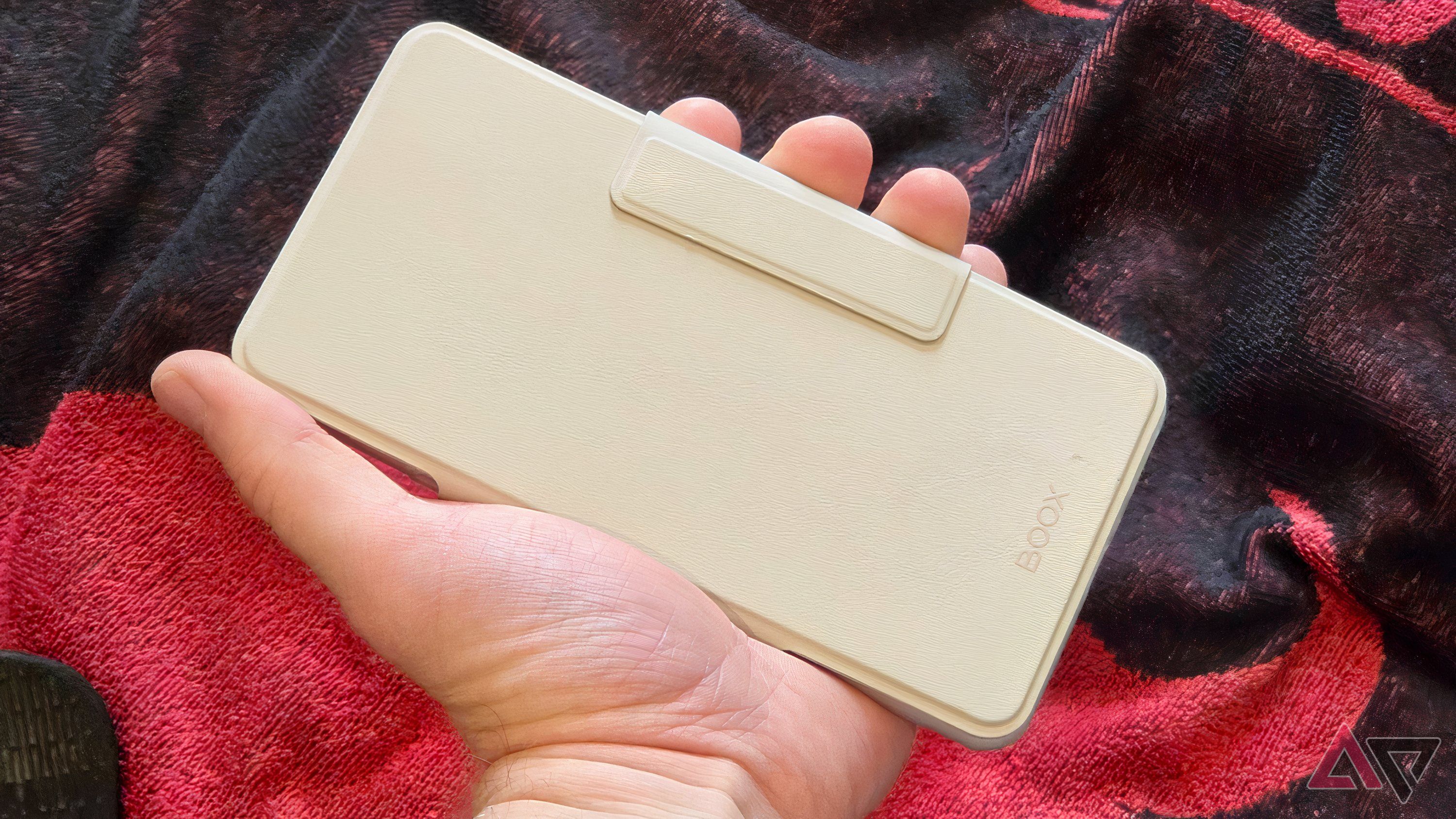 The Onyx Palma 2 Pro, closed in its folio, in a man's hand.