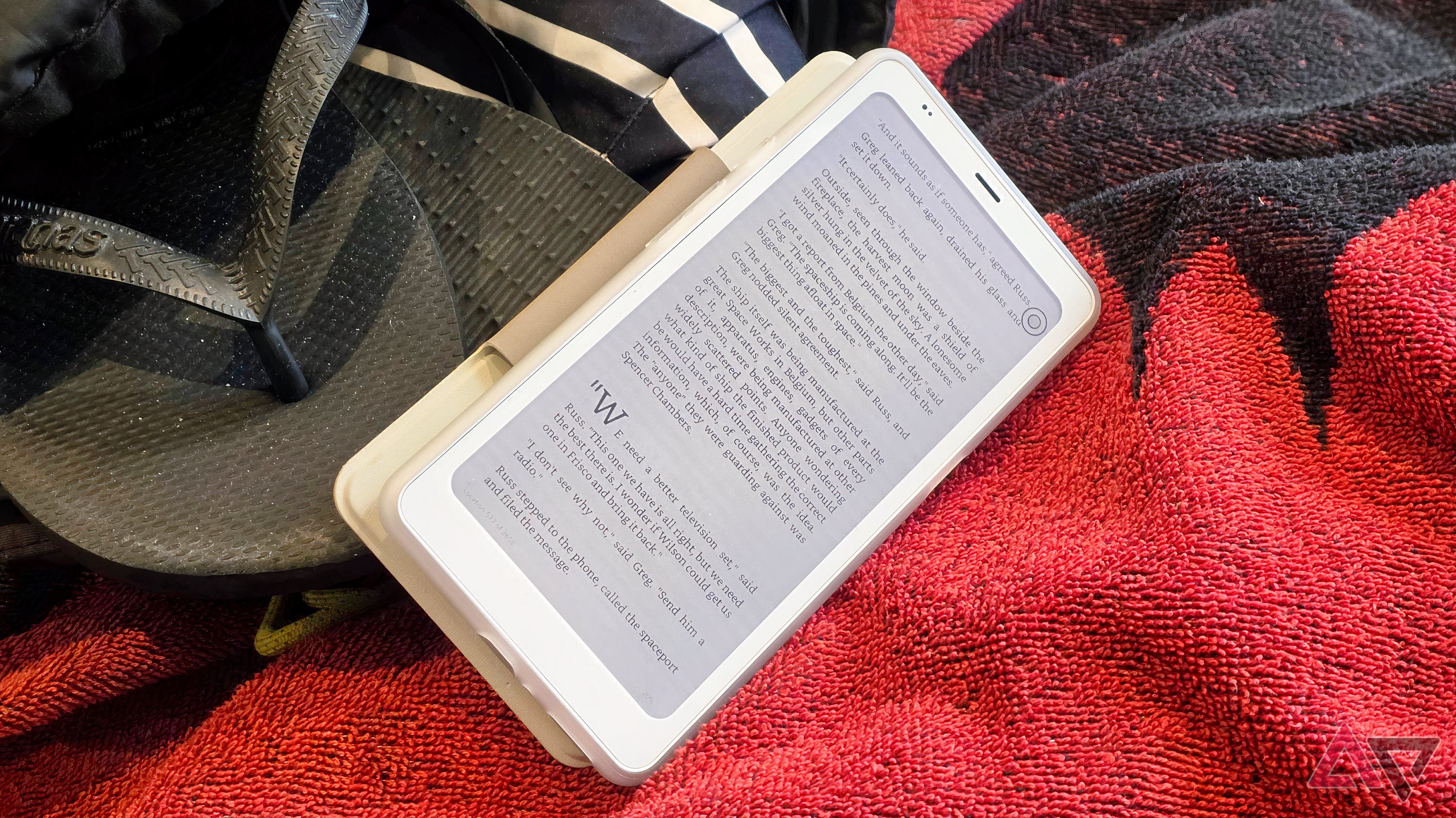 The Onyx Palma 2 Pro, leaning on a packed backpack, with a book displayed.
