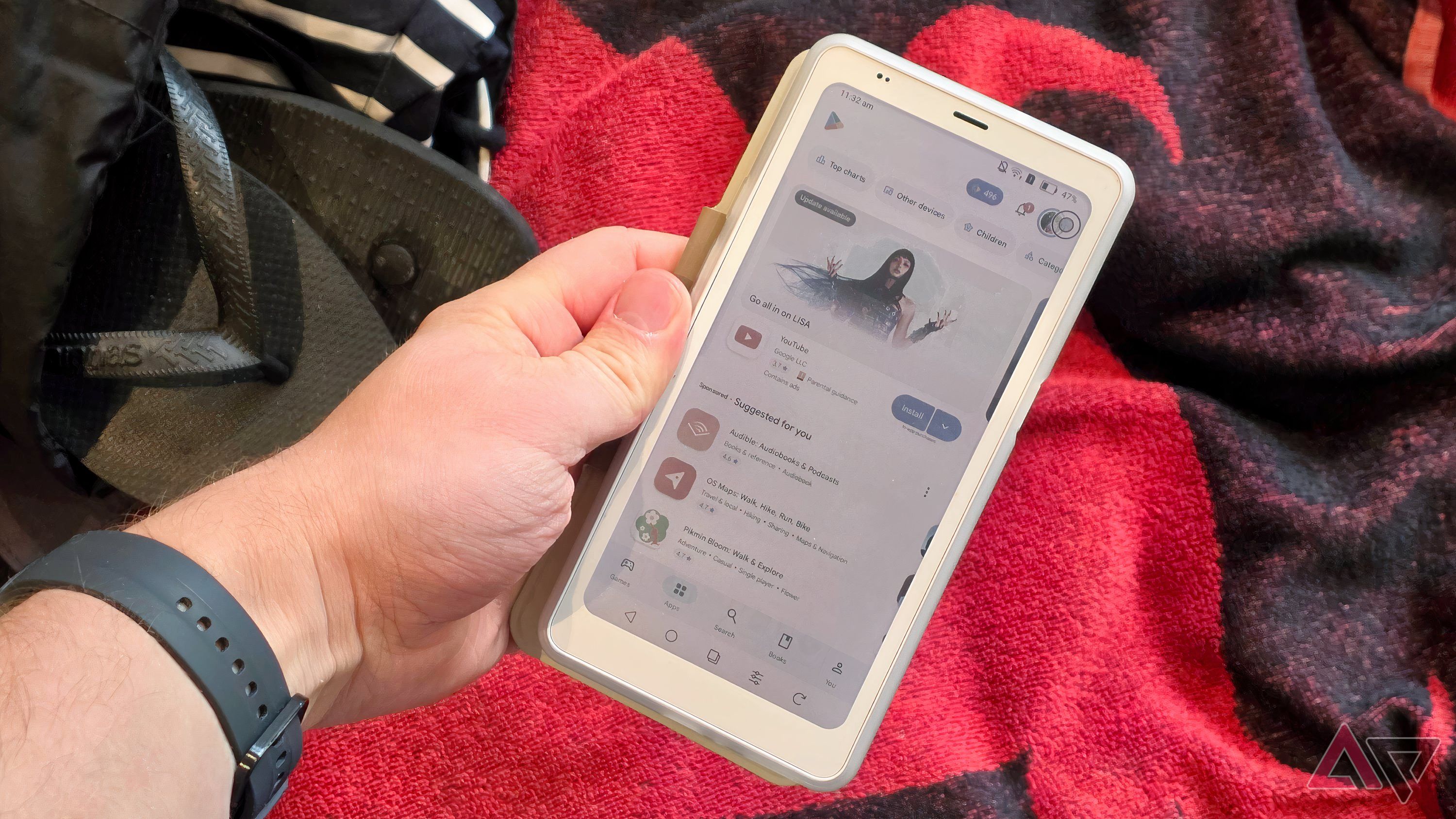 The Onyx Palma 2 Pro, in a man's hand, showing the Play Store.