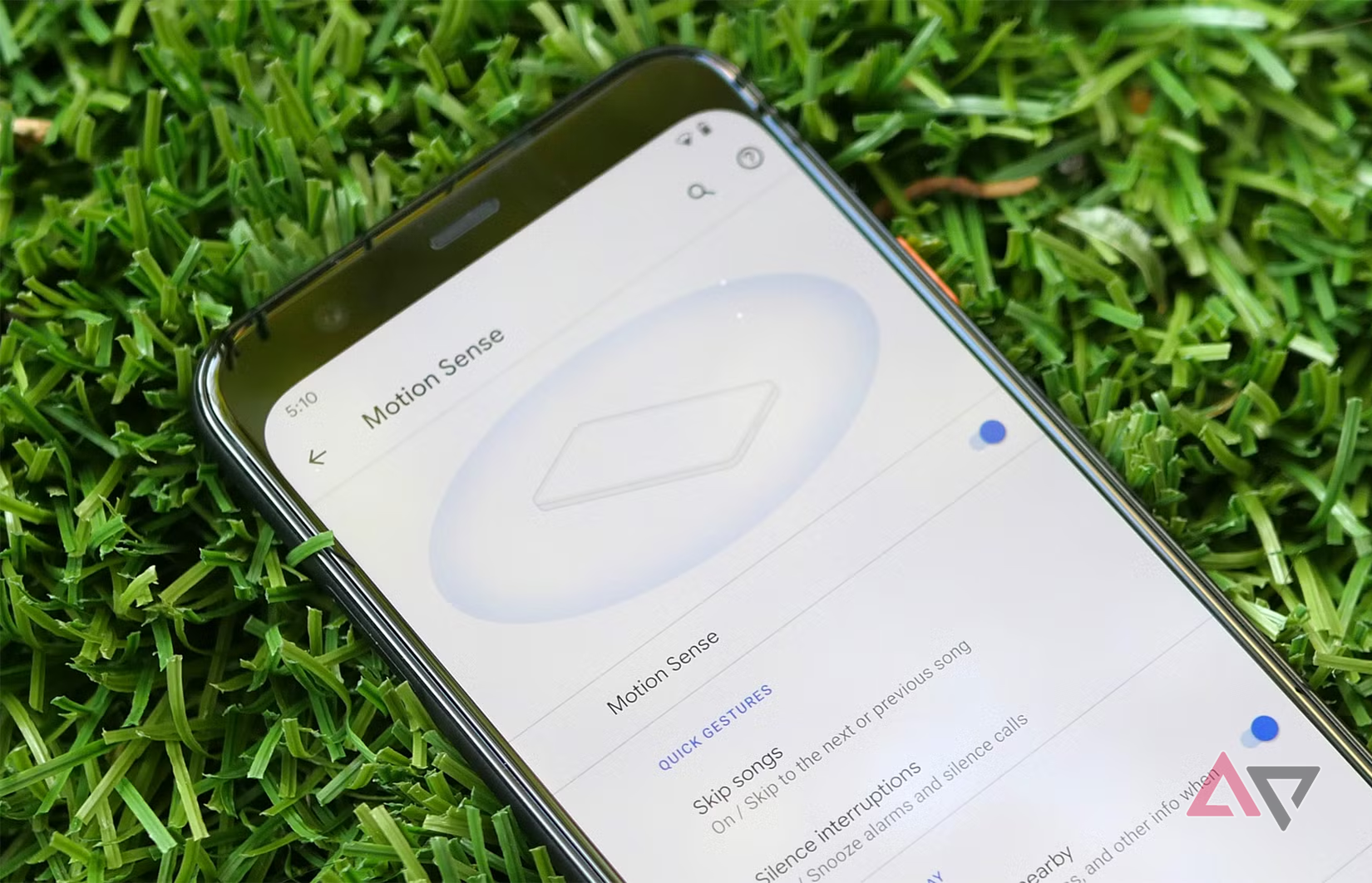 telefono sdraiato sull'erba con la pagina delle impostazioni del rilevamento del movimento aperta