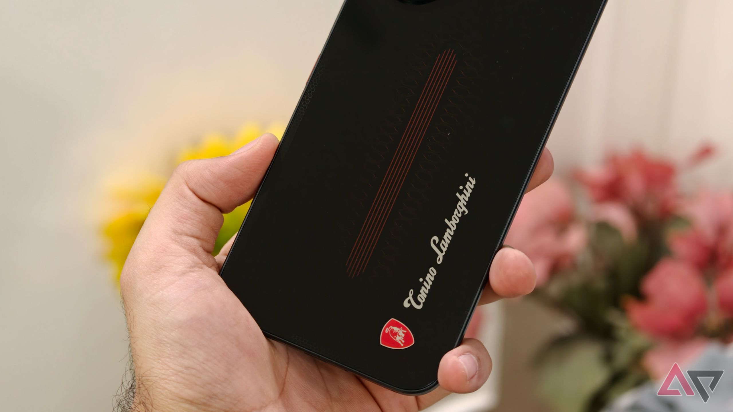 Close-up shot of the lower rear glass panel of the Tecno phone displaying the Tonino Lamborghini logo